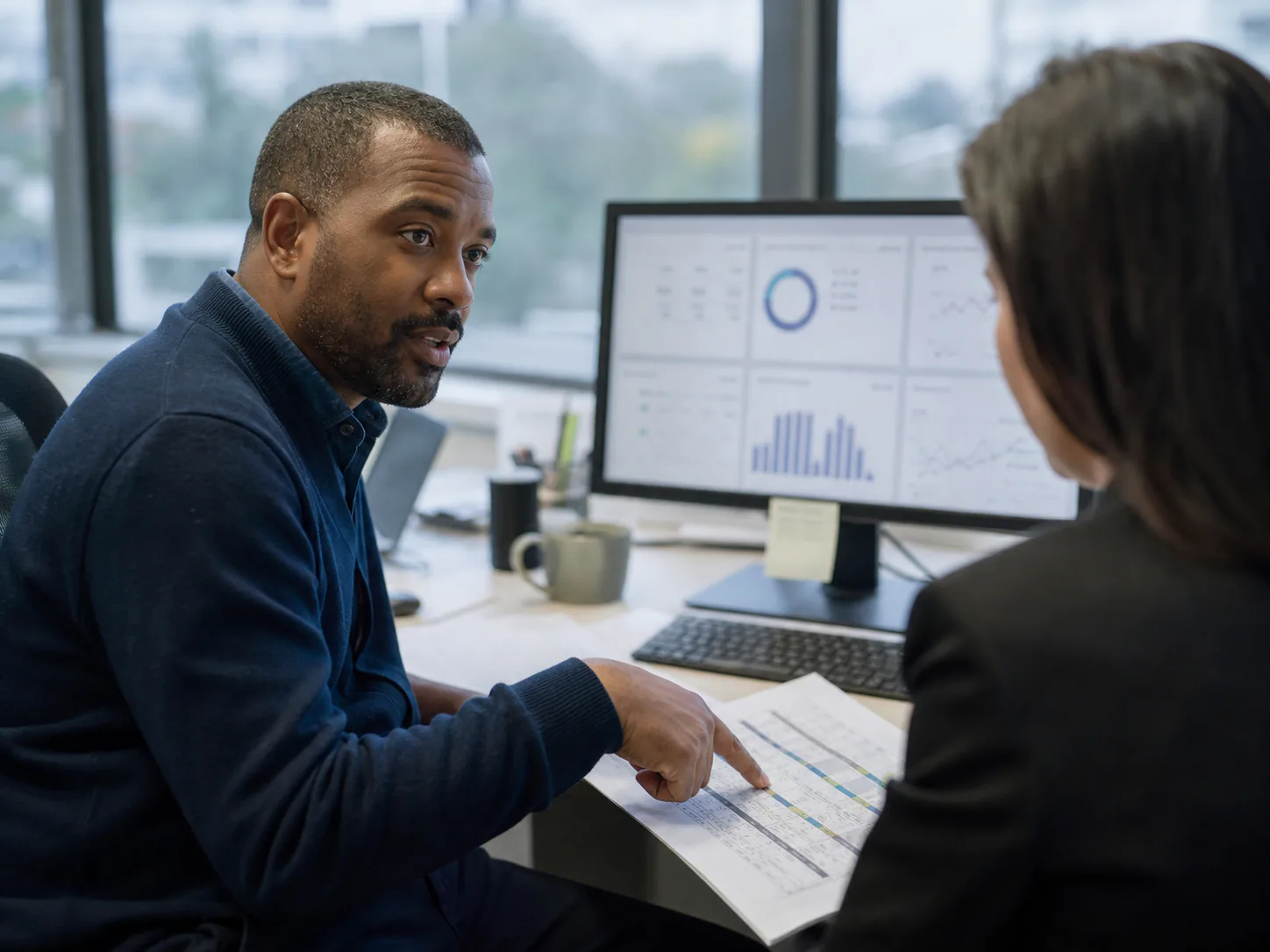 Operations lead reviewing a schedule with a colleague, representing internal business systems.
